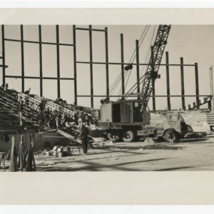 Crane being operated on interior of Dorton Arena during its construction