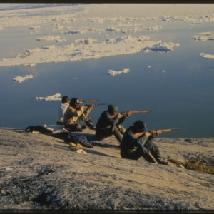 Men with rifles along shore, circa 1969-1982