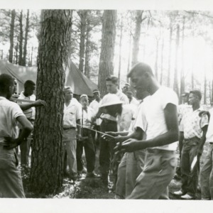 Photo of Men Being Instructed at Camp