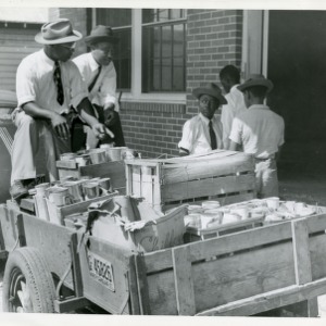 Photo of Men and Young Boys Near Cart