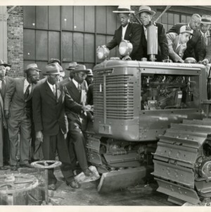 Photo of Men Inspecting a Tractor