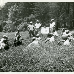 Photo of A Young Group of Farmers Sitting in a Field