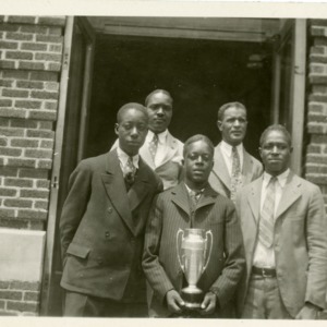Group Photo of Colored Team holding a Trophy