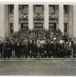 Photograph of NFA members gathered in front of the Dudley Building with S.B. Simmons, front row to the right of the center wearing the NFA Owl apron.