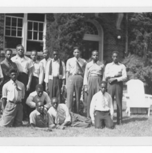 Picture of a group of young men in from of a brick building