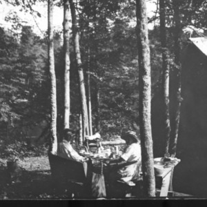 Two people outside a tent