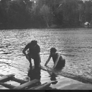 Two people climbing out of lake