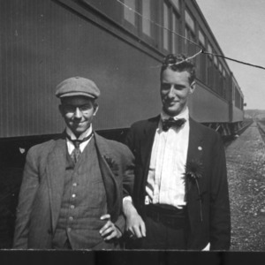 Men posing next to train
