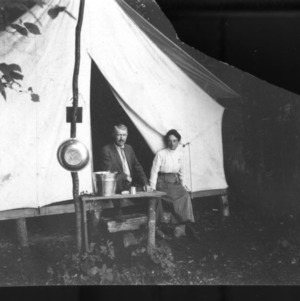Two people in front of a tent