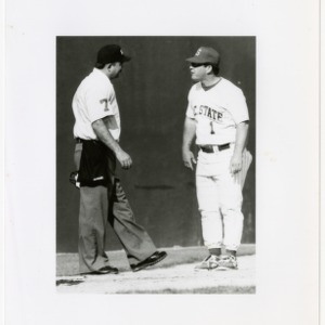 NC State coach stands and talks to umpire