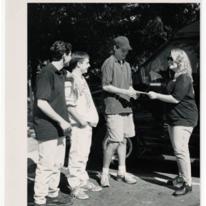 Two radio show representatives present students with a $1000 check