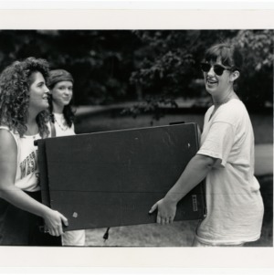 Students carry a refrigerator into the Tri-Towers