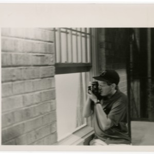 Boy shooting photograph out the window