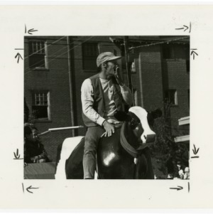 Jim Varney as character Ernest riding Bessie the Cow on Pine State float in 1986 Raleigh Christmas parade