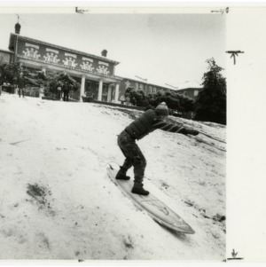 Student snow surfs on campus
