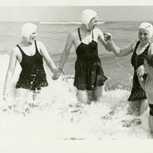 Two women and a boy wearing vintage swimwear at the beach