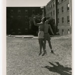 Two students jump for the frisbee