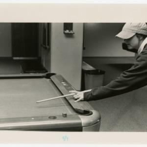 Student sets up a shot at the pool table
