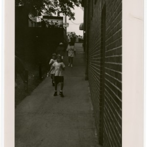 Children slurping drinks while walking down the sidewalk