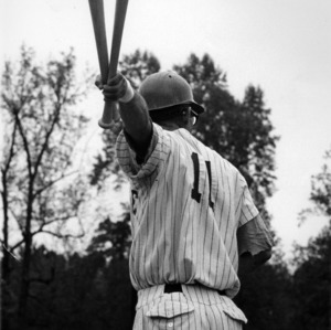 Baseball player, possibly North Carolina State outfielder Robert Andrews, holding bats