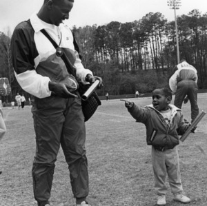 Darrian Bryant and little boy with batons on field