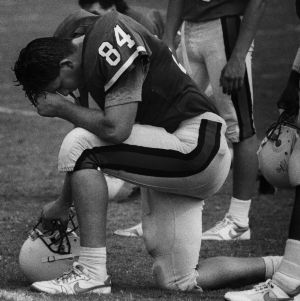 Football player Todd Harrison kneeling during practice