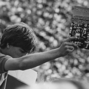 Young man with programs at game