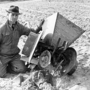 Man with ertilizer distributor machinery in field