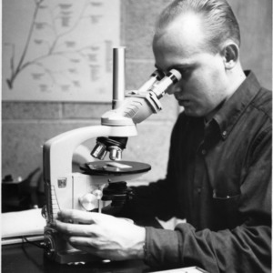 Dr. Ernest Hodgson at microscope in Physiology Laboratory