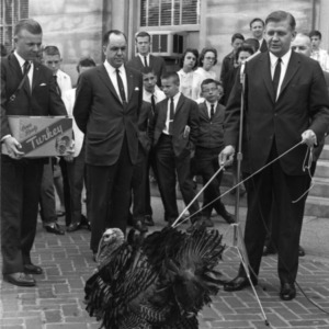 Governor Terry Sanford with turkey "Chef Boy" on leash