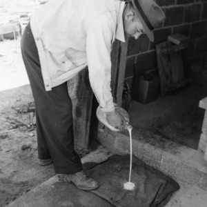 Man disinfecting mat at brooder house