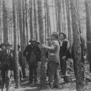Mr. R.L. McLurd and a group of his neighbors studying plans for management of this crop of shortleaf pines