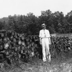 John Brown in front of shortleaf pine billets