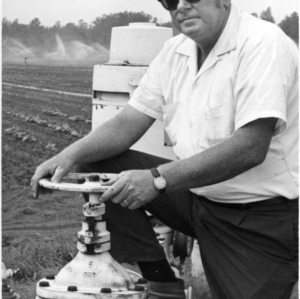 E. J. Bundy opperating irrigation system for cucumber field