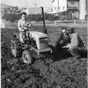 Men examining tractor at Iseki Agricultural Machinery Company Limited plant