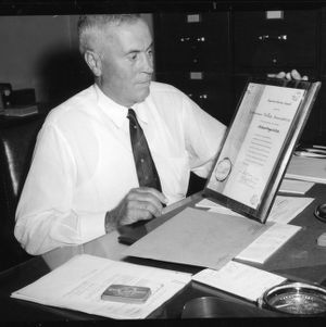 Man at desk with Superior Service Award from the Tennessee Valley Authority