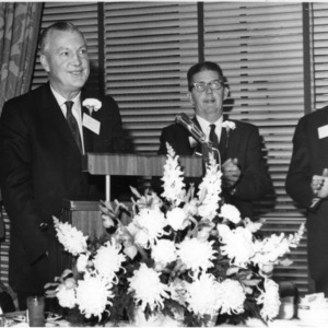 Governor Dan K. Moore and two others at podium