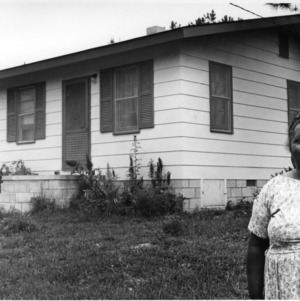 Unidentified woman in front of house
