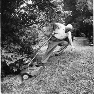 Lawn mower safety demonstration photograph showing a man slipping