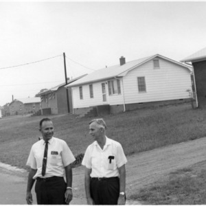 Two unidentified men standing on a neighborhood street