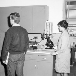 Students, woman with microscope