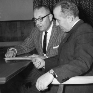 Two Men Reading Document