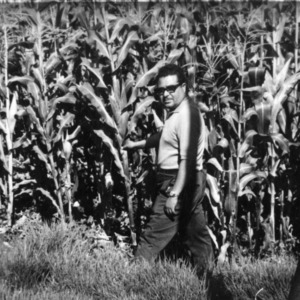 Manuel Oparto, Zone Director, looks over corn demonstration of the N.C. Mission