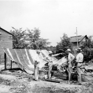 Men with tarp on farm