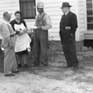 Mr. and Mrs. J. E. Murphy delivering their first can for new milk route and receiving instruction from Agent Neil M. Smith