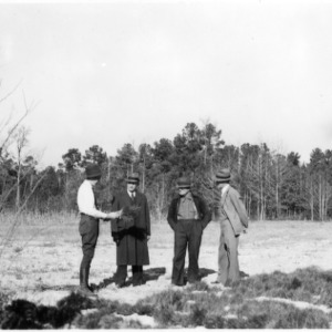 Foresters and tenant farmer examining tree seedlings