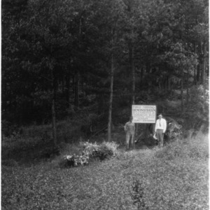 C. E. Forester and Agent K. A. Haney in front of sign notifying forest thinning demonstration