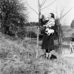 Mrs. A. H. Pell admiring three-year-old walnut seedling