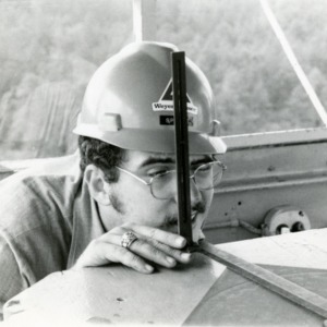 Man in hardhat with measuring instrument