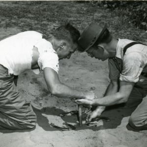 Two men playing horseshoes